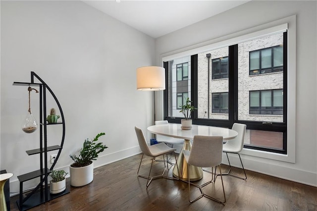 dining space featuring dark wood finished floors and baseboards