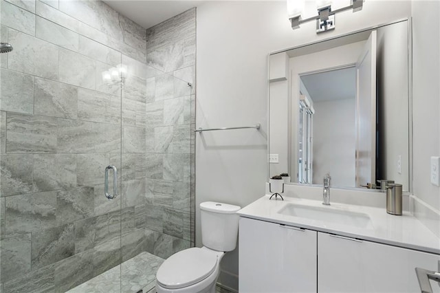 bathroom with a stall shower, vanity, and toilet