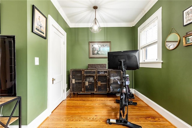 workout area with baseboards, wood finished floors, and ornamental molding