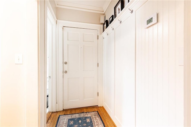 entryway featuring ornamental molding and light wood-style flooring