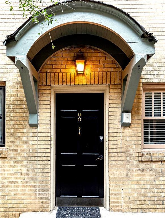 doorway to property featuring brick siding