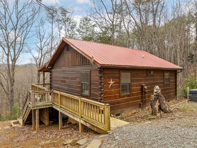 view of home's exterior featuring a wooden deck, crawl space, stairway, and metal roof