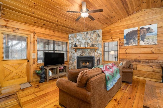 living room featuring hardwood / wood-style flooring, vaulted ceiling, ceiling fan, wood ceiling, and wooden walls