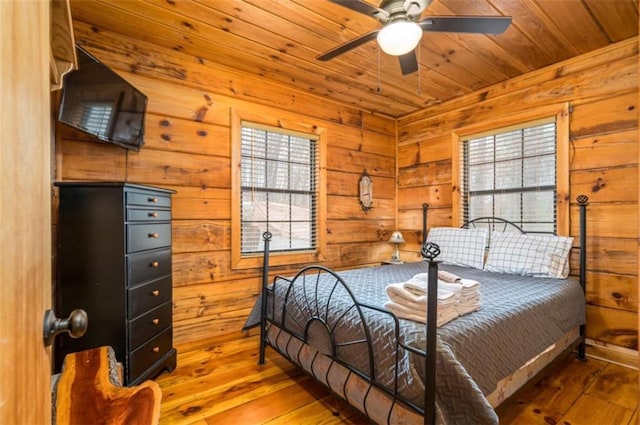 bedroom with wood ceiling, wood-type flooring, and wooden walls