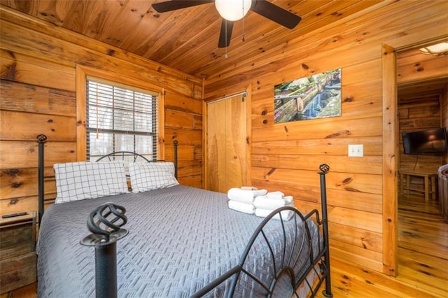 bedroom featuring wooden ceiling, wood finished floors, and wooden walls