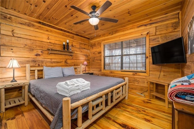 bedroom with wood ceiling, hardwood / wood-style floors, and wooden walls