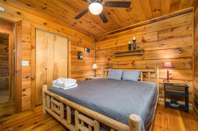 bedroom with hardwood / wood-style floors, wooden ceiling, and wooden walls