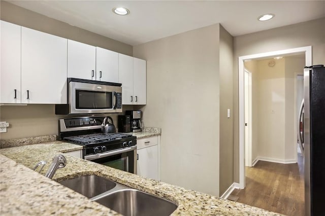 1209 Brookhaven Woods Ct NE, Brookhaven, GA 30319 - kitchen with appliances with stainless steel finishes, wood finished floors, a sink, light stone countertops, and white cabinetry