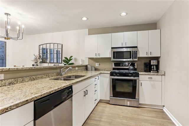 1209 Brookhaven Woods Ct NE, Brookhaven, GA 30319 - kitchen with appliances with stainless steel finishes, a sink, light wood-style flooring, a chandelier, and white cabinetry