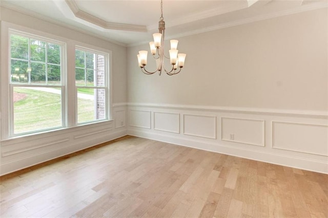 3292 Mill Forest Dr, Conyers, GA 30094 - empty room with a tray ceiling, ornamental molding, a chandelier, light wood-style flooring, and a wainscoted wall