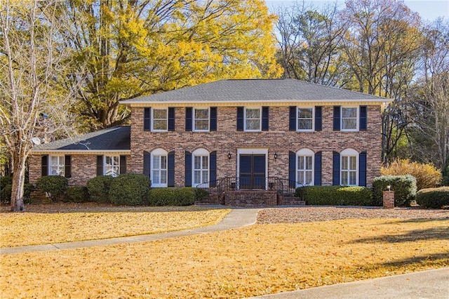 colonial-style house featuring a front yard