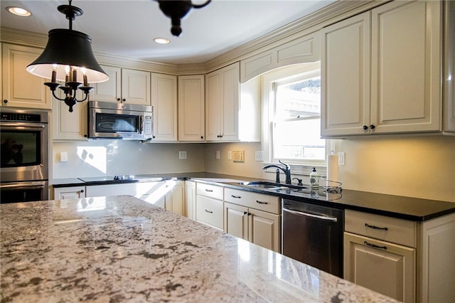 kitchen featuring pendant lighting, stainless steel appliances, dark stone counters, and cream cabinets