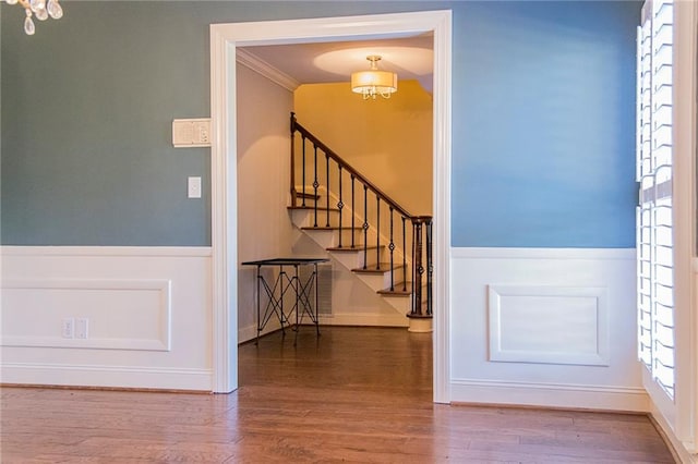 entryway featuring wood-type flooring and crown molding