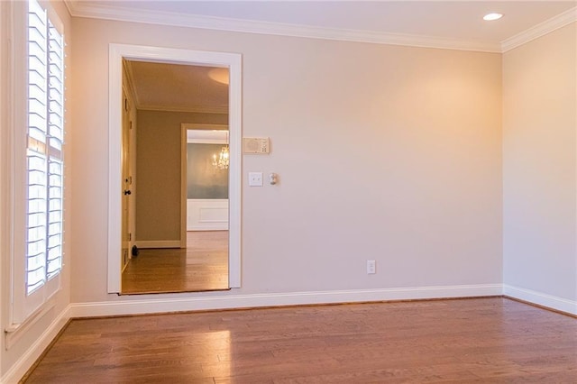 empty room featuring wood-type flooring and crown molding