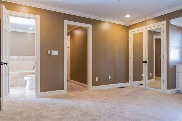 unfurnished bedroom featuring ornamental molding, light carpet, and connected bathroom