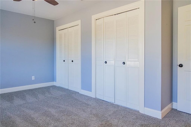 unfurnished bedroom with carpet flooring, two closets, and ceiling fan