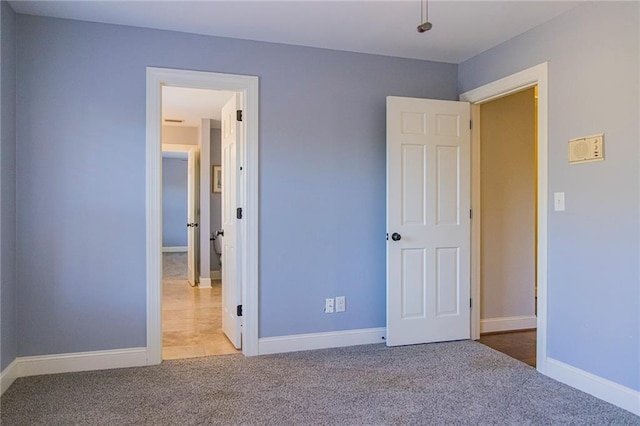 unfurnished bedroom featuring light carpet