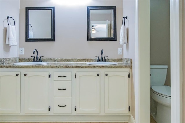 bathroom with vanity, ceiling fan, and toilet