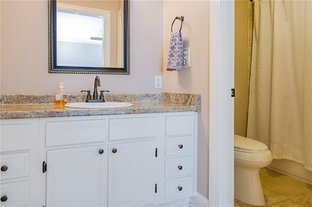 bathroom featuring tile patterned flooring, vanity, and toilet