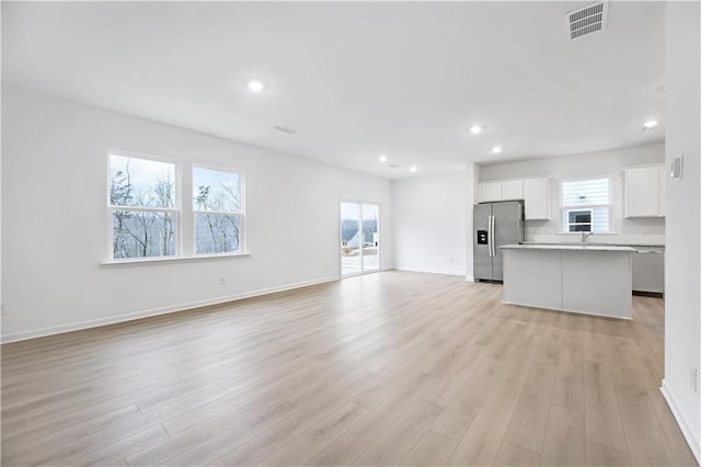 unfurnished living room featuring light hardwood / wood-style flooring and plenty of natural light