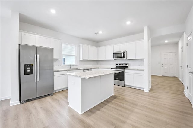 kitchen with white cabinetry, appliances with stainless steel finishes, and a kitchen island