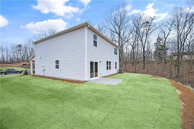 view of side of home featuring a patio, a yard, and central AC