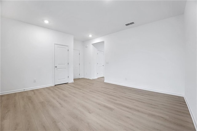 kitchen with a kitchen island, appliances with stainless steel finishes, sink, light stone counters, and light hardwood / wood-style floors