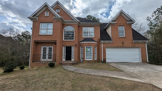 view of front facade with driveway, french doors, a front yard, a garage, and brick siding