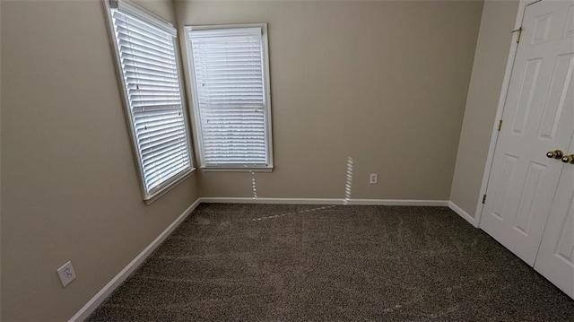 spare room with baseboards and carpet floors