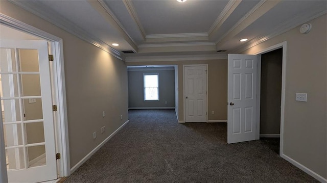 corridor with visible vents, baseboards, crown molding, a raised ceiling, and dark colored carpet