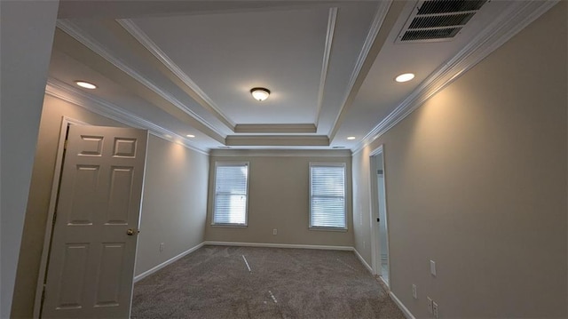 unfurnished room featuring a tray ceiling, visible vents, baseboards, and carpet flooring