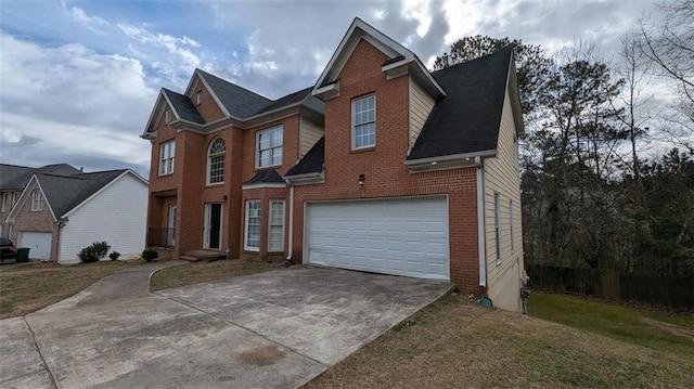 traditional-style home with brick siding, an attached garage, and driveway