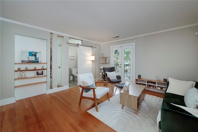 2023 Oakview Rd SE Unit 226, Atlanta, GA 30317 - living room with ornamental molding, a barn door, wood finished floors, and french doors