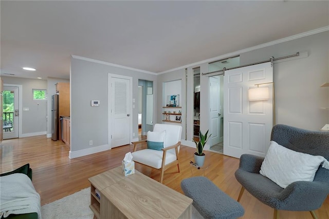2023 Oakview Rd SE Unit 226, Atlanta, GA 30317 - living area featuring a barn door, light wood-style flooring, and ornamental molding
