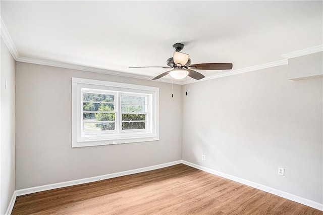 spare room with ornamental molding, wood finished floors, a ceiling fan, and baseboards