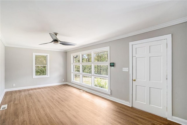 unfurnished room with a wealth of natural light, baseboards, and wood finished floors