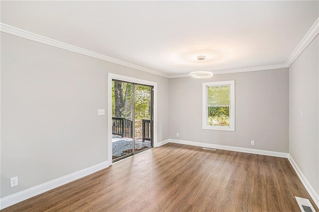 unfurnished room featuring wood finished floors, visible vents, and baseboards