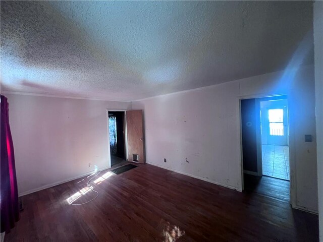 unfurnished room featuring a textured ceiling and dark wood-type flooring