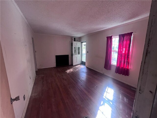 unfurnished living room featuring a textured ceiling, crown molding, and dark hardwood / wood-style floors