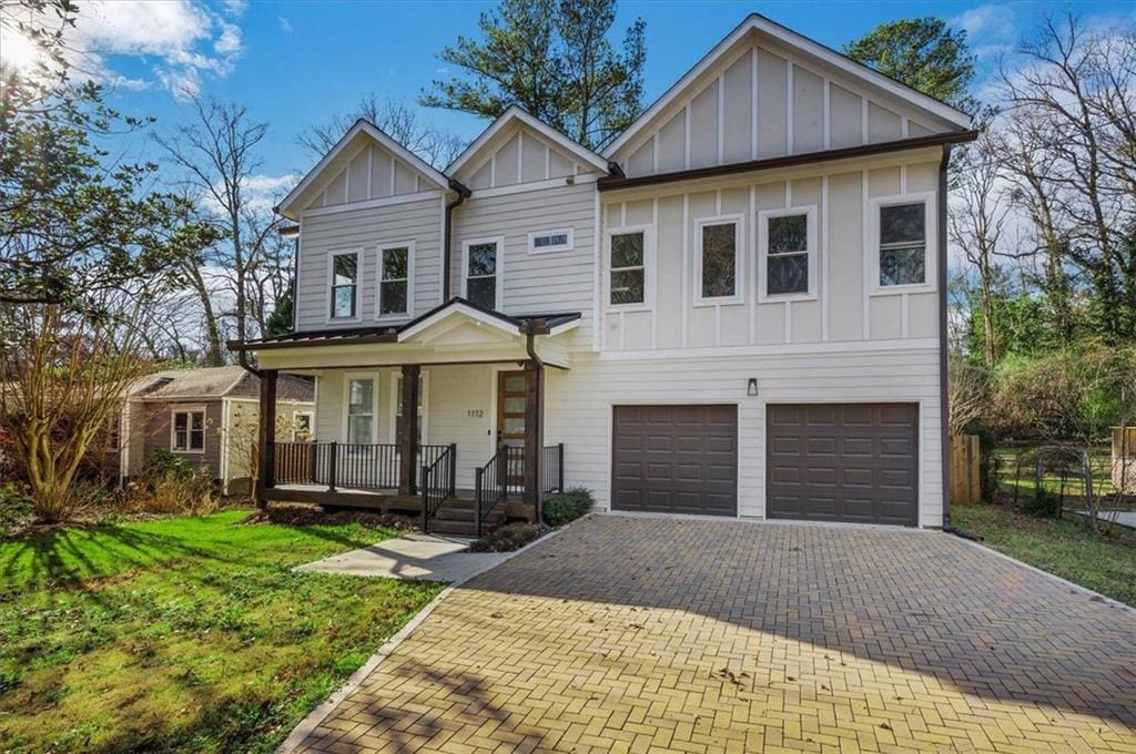 view of front of house featuring a front yard, a porch, and a garage