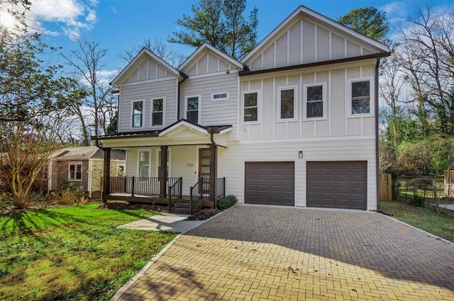 view of front of house featuring a front yard, a porch, and a garage