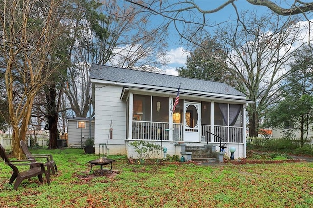 view of front of house with a sunroom and a front yard