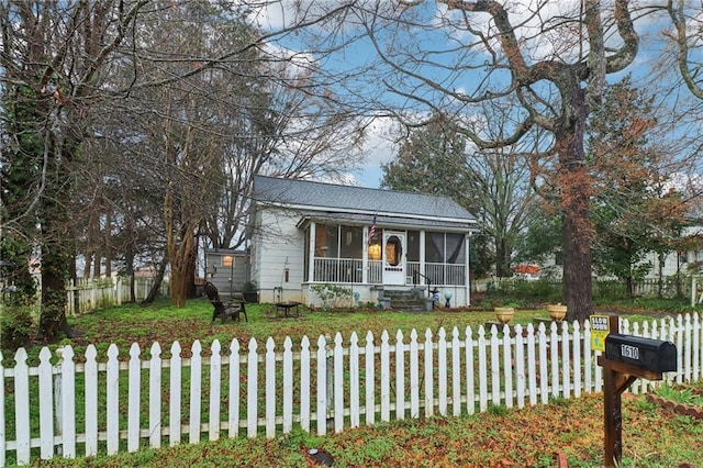 view of front facade with a sunroom and a front yard