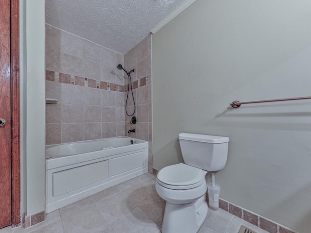 bathroom with tile patterned flooring, a textured ceiling, tiled shower / bath combo, and toilet