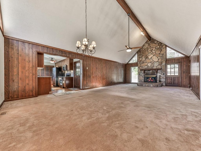 unfurnished living room with wood walls, high vaulted ceiling, a fireplace, beam ceiling, and light colored carpet