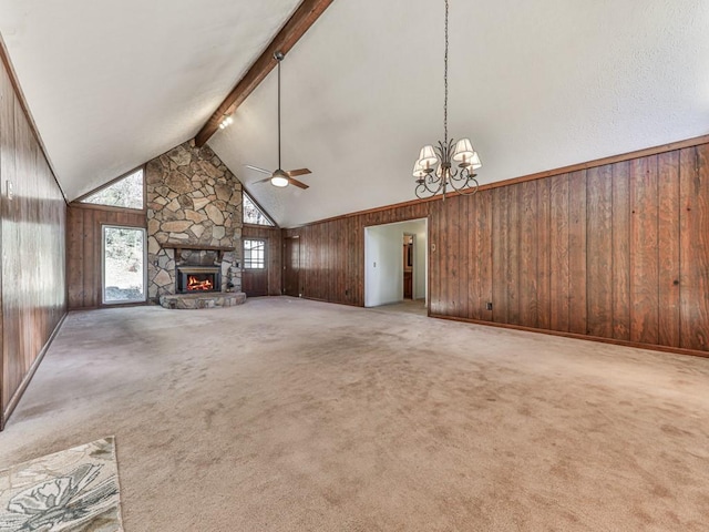 unfurnished living room featuring beamed ceiling, ceiling fan with notable chandelier, a fireplace, and carpet