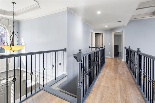 hall featuring a chandelier, light wood-type flooring, and crown molding