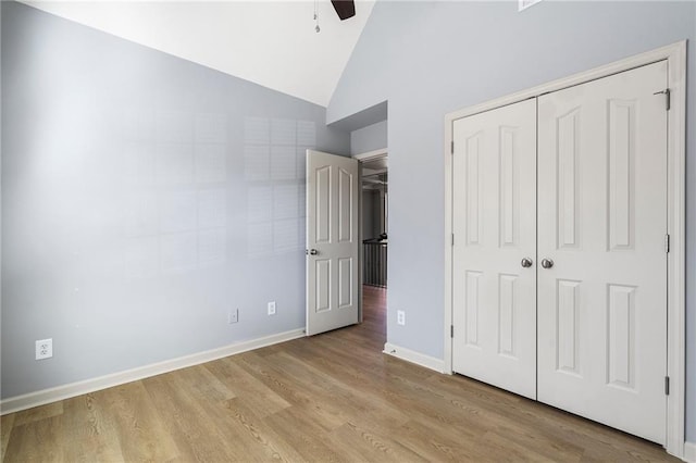 unfurnished bedroom with ceiling fan, a closet, vaulted ceiling, and light hardwood / wood-style flooring