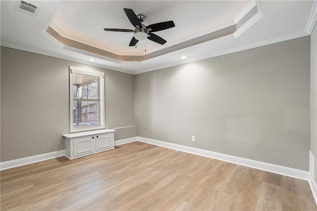 spare room with a tray ceiling, crown molding, and ceiling fan