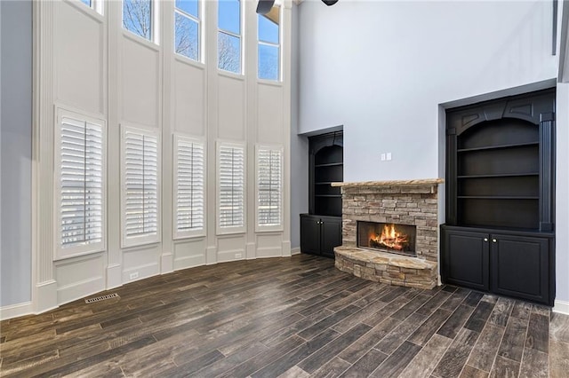 unfurnished living room featuring a fireplace and a high ceiling